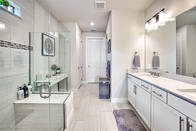 bathroom featuring vanity, a shower with shower door, and tile patterned flooring