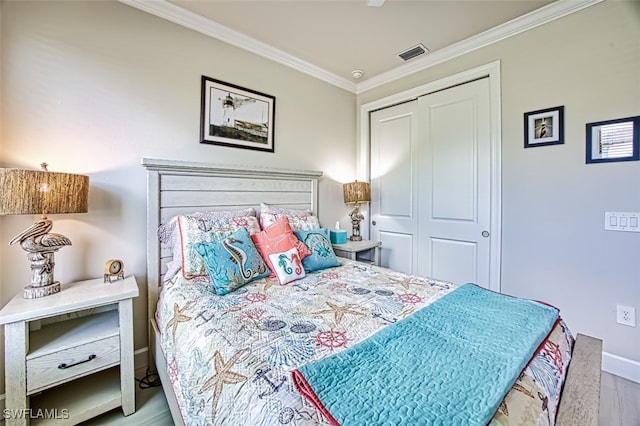 bedroom with crown molding, light hardwood / wood-style floors, and a closet