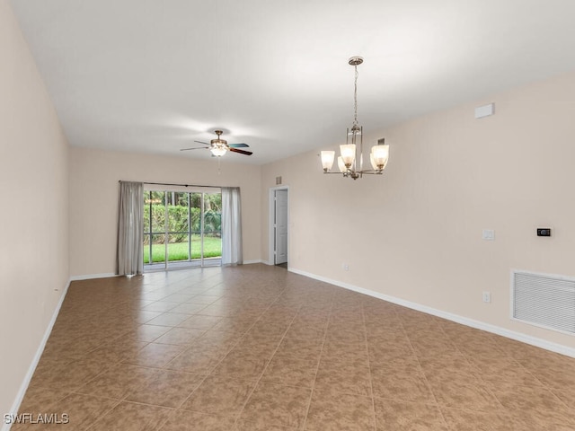 empty room with ceiling fan with notable chandelier and light tile patterned floors