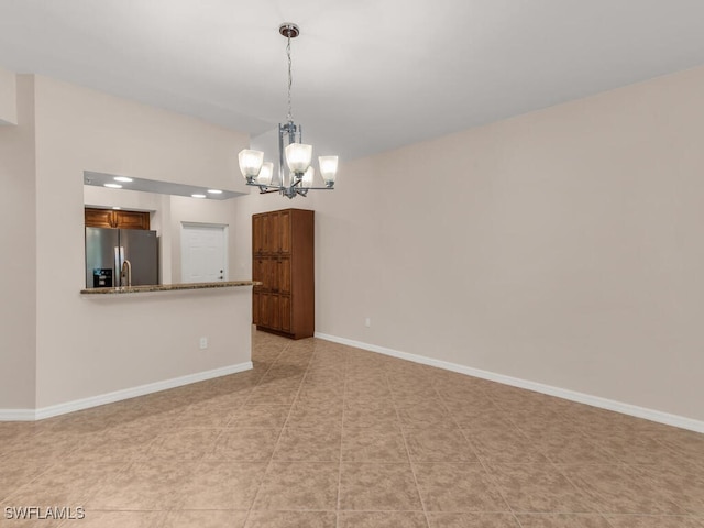 tiled empty room with an inviting chandelier