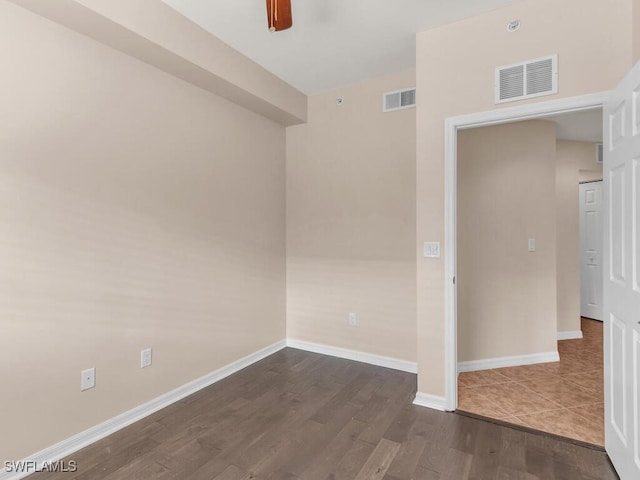 spare room with dark wood-type flooring and ceiling fan