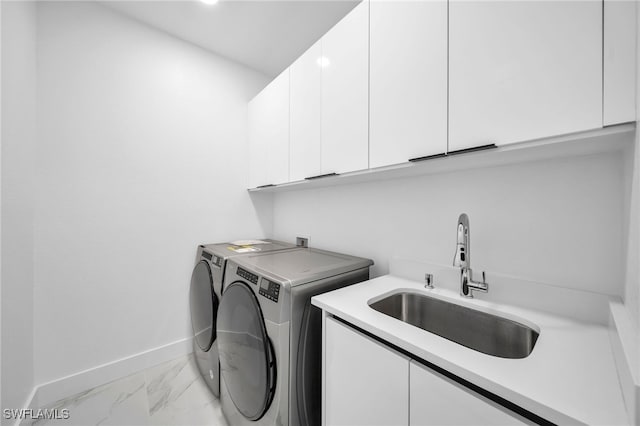 laundry room featuring sink, independent washer and dryer, and cabinets