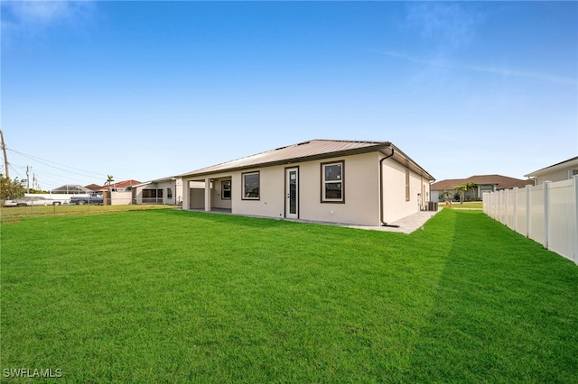 rear view of house featuring central air condition unit and a lawn