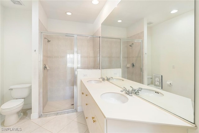 bathroom with tile patterned flooring, vanity, toilet, and an enclosed shower