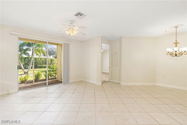 spare room with light tile patterned floors and ceiling fan with notable chandelier