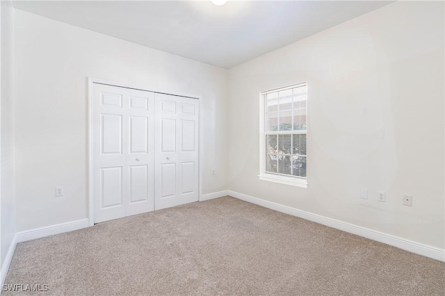 unfurnished bedroom with carpet flooring and a closet