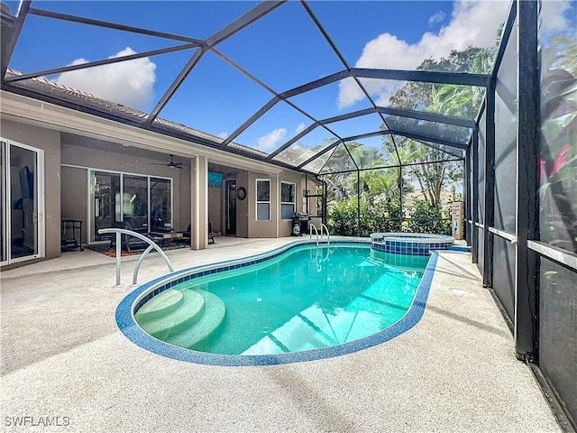 view of swimming pool with glass enclosure, a patio, a ceiling fan, and a pool with connected hot tub