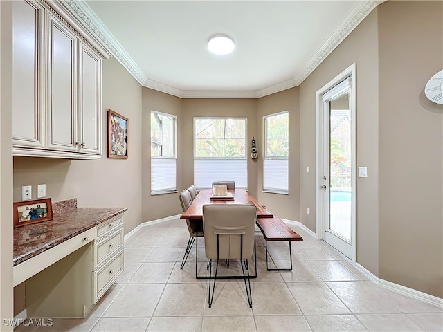 dining space featuring light tile patterned floors, baseboards, and crown molding