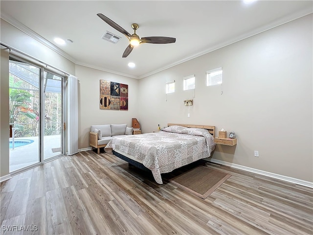 bedroom with wood finished floors, visible vents, baseboards, access to exterior, and crown molding