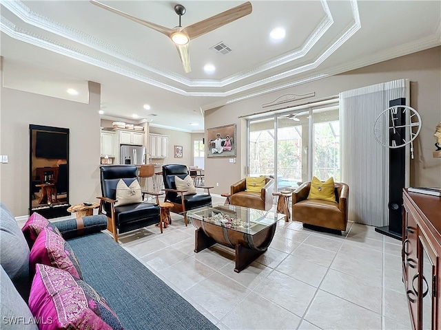 tiled living room featuring ceiling fan, a raised ceiling, and crown molding