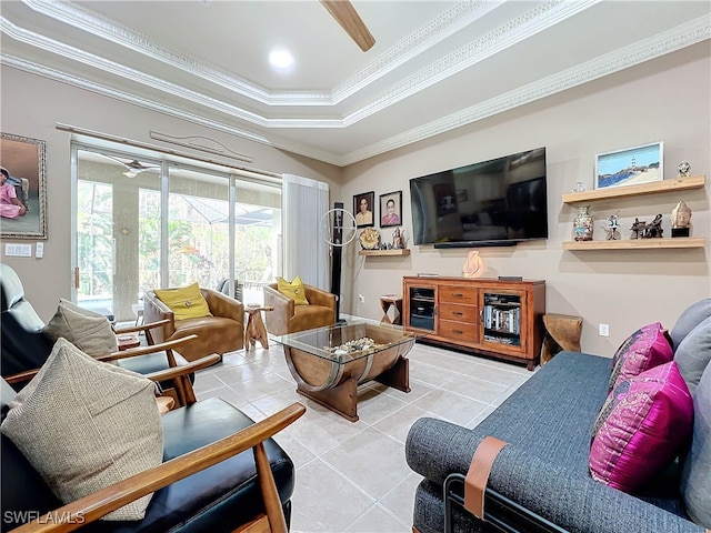 living room featuring tile patterned flooring, a tray ceiling, crown molding, and ceiling fan