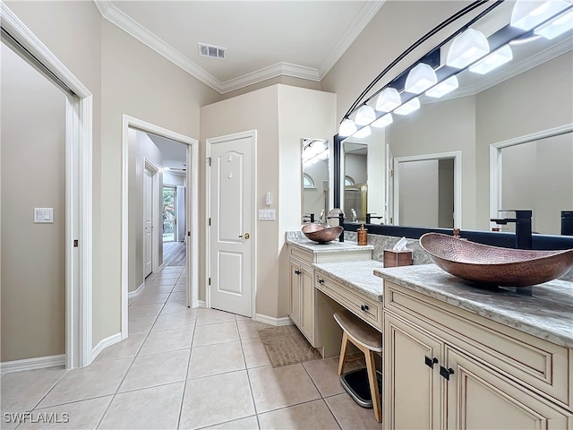 bathroom with visible vents, double vanity, ornamental molding, a sink, and tile patterned floors