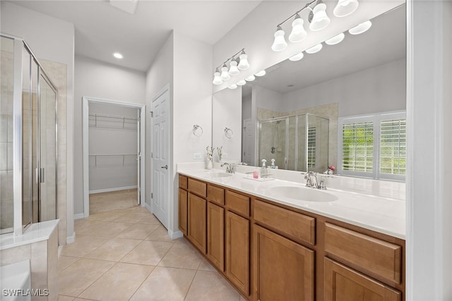 bathroom with a shower with door, vanity, and tile patterned flooring