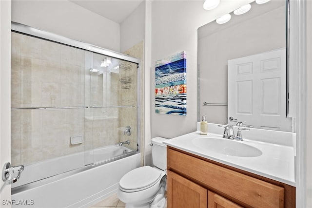 full bathroom featuring toilet, combined bath / shower with glass door, vanity, and tile patterned flooring