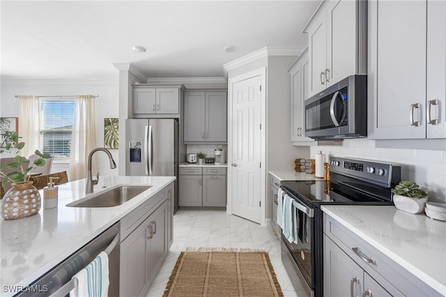 kitchen with gray cabinetry, stainless steel appliances, decorative backsplash, and sink