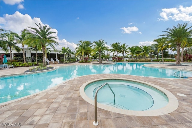 view of pool with a hot tub and a patio area