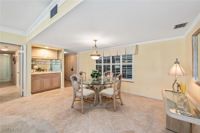 dining room featuring crown molding and light tile patterned floors