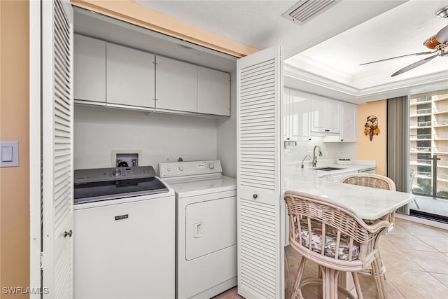 laundry room featuring cabinets, light tile patterned floors, ceiling fan, separate washer and dryer, and sink