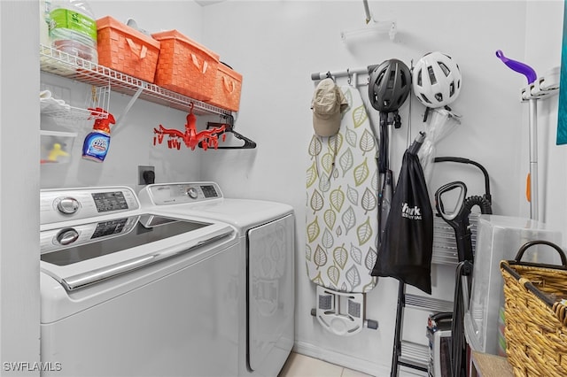 clothes washing area with light tile patterned floors and washing machine and clothes dryer