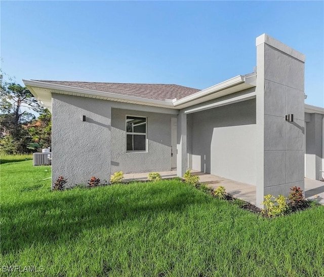 view of front of home featuring cooling unit and a front lawn