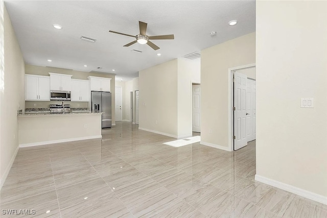 unfurnished living room with ceiling fan and sink