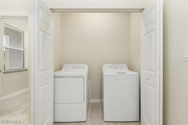 washroom with light hardwood / wood-style flooring and washing machine and clothes dryer