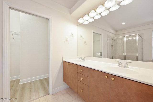 bathroom with tile patterned flooring, vanity, and a shower with door