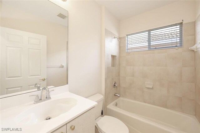 full bathroom with tiled shower / bath combo, toilet, and vanity