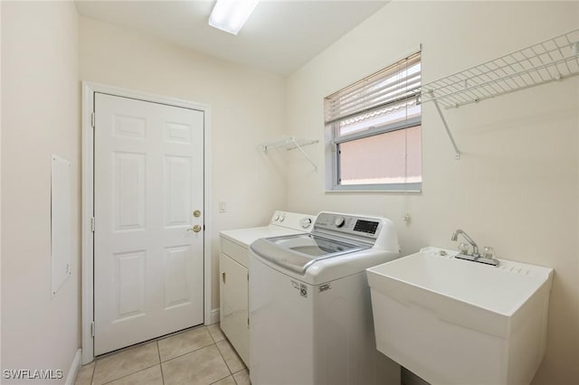 laundry room featuring separate washer and dryer, sink, and light tile patterned floors