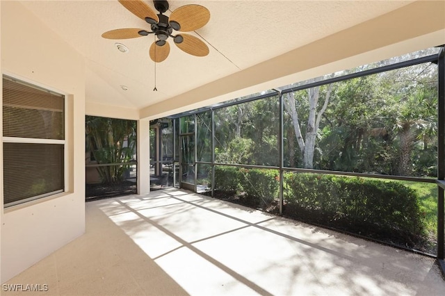 unfurnished sunroom featuring ceiling fan and vaulted ceiling