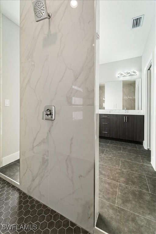 bathroom with vanity and tiled shower