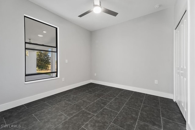 tiled empty room featuring ceiling fan