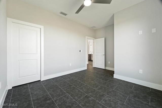 unfurnished room with dark tile patterned floors and ceiling fan