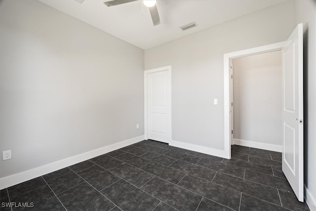 interior space featuring dark tile patterned flooring and ceiling fan