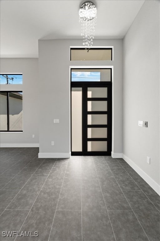 tiled foyer entrance featuring a notable chandelier