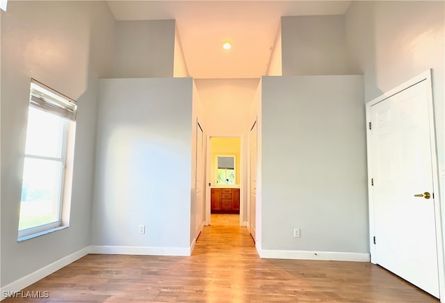 unfurnished room with light hardwood / wood-style floors and a high ceiling