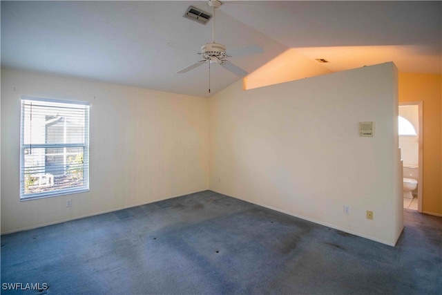 carpeted spare room with ceiling fan and vaulted ceiling