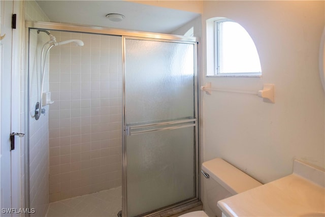 bathroom featuring toilet, an enclosed shower, and vanity