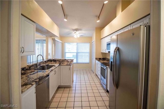 kitchen with rail lighting, stainless steel appliances, sink, and white cabinets