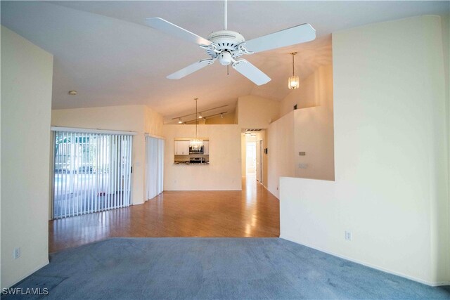 unfurnished living room featuring hardwood / wood-style flooring, ceiling fan, and vaulted ceiling