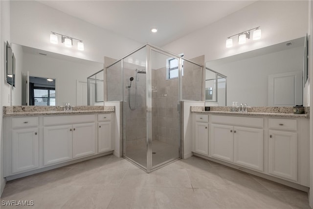 bathroom with vanity, a shower with shower door, and tile patterned flooring