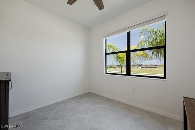 tiled spare room with ceiling fan