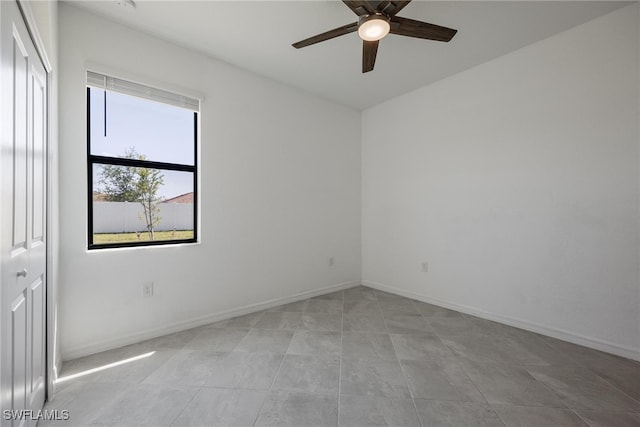 empty room featuring light tile patterned floors and ceiling fan