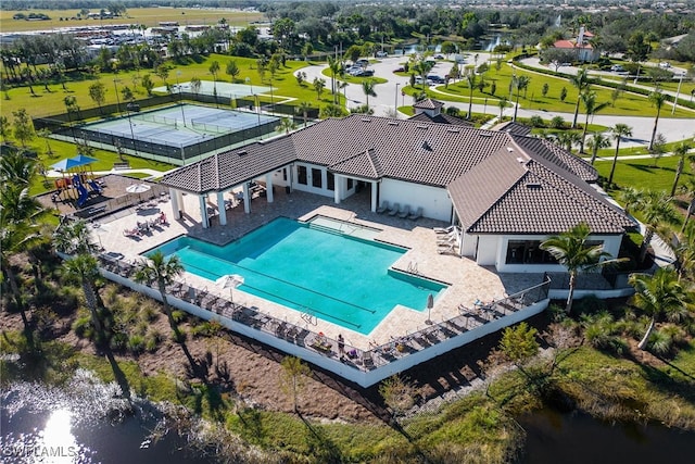 view of pool with a patio and a water view