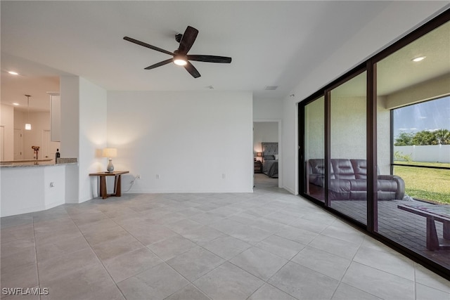 unfurnished living room featuring light tile patterned flooring and ceiling fan