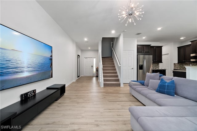 living room featuring light hardwood / wood-style flooring and an inviting chandelier