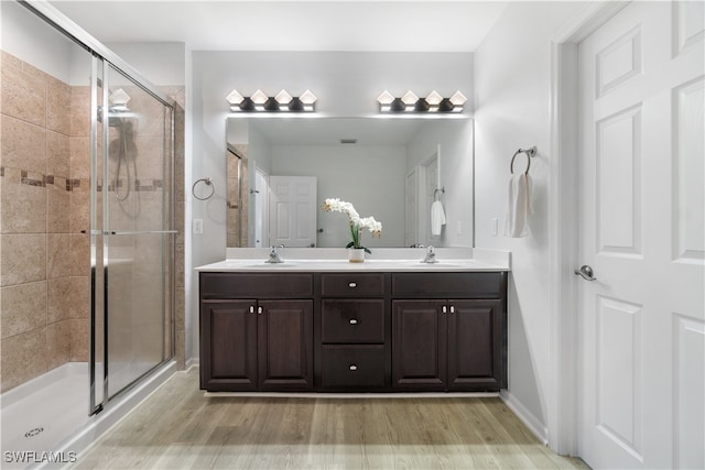 bathroom with a shower with door, vanity, and hardwood / wood-style flooring