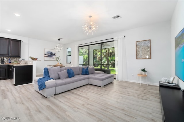 living room with a notable chandelier and light wood-type flooring