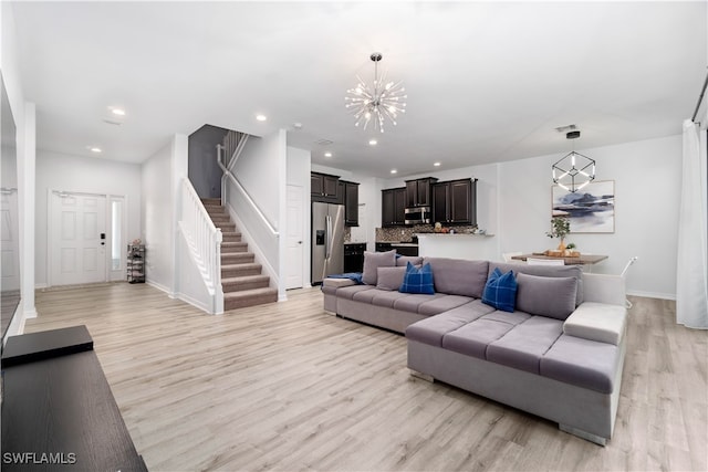 living room with light hardwood / wood-style flooring and a chandelier