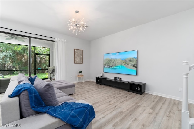 living room featuring light hardwood / wood-style floors and ceiling fan with notable chandelier